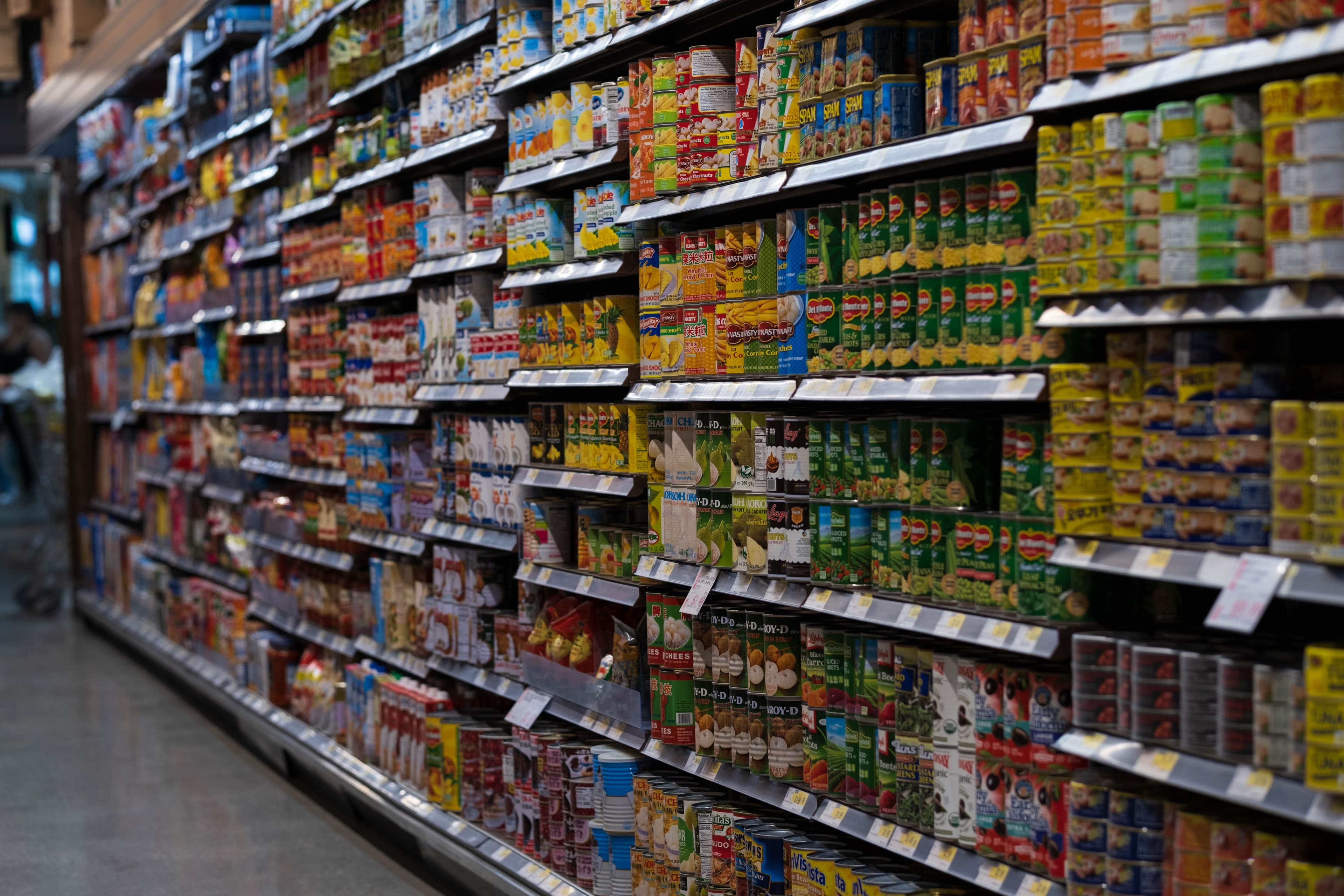Supermarket shelves lined with priced stock.
